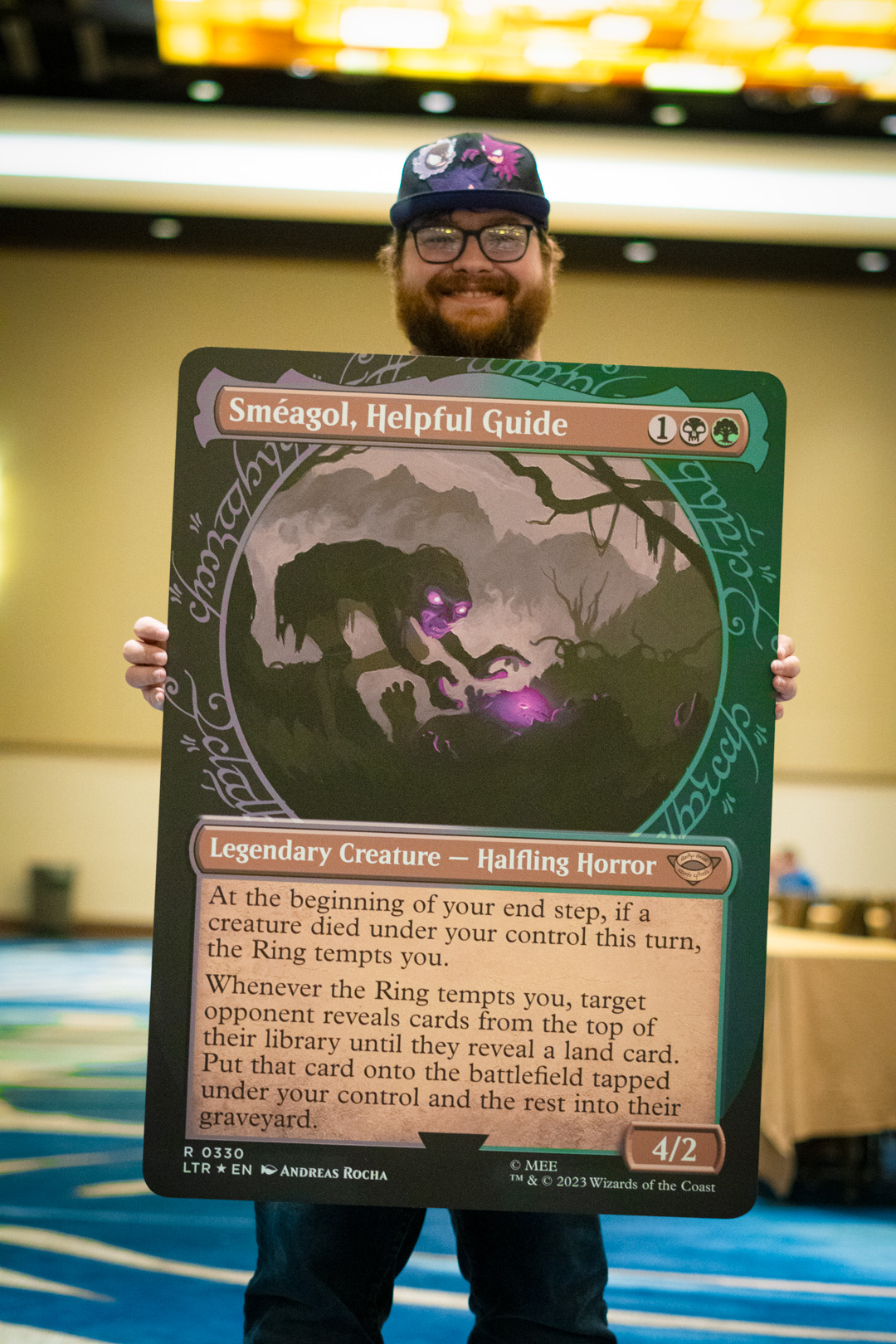 Player holding an oversized card of Smeagol, Helpful Guide