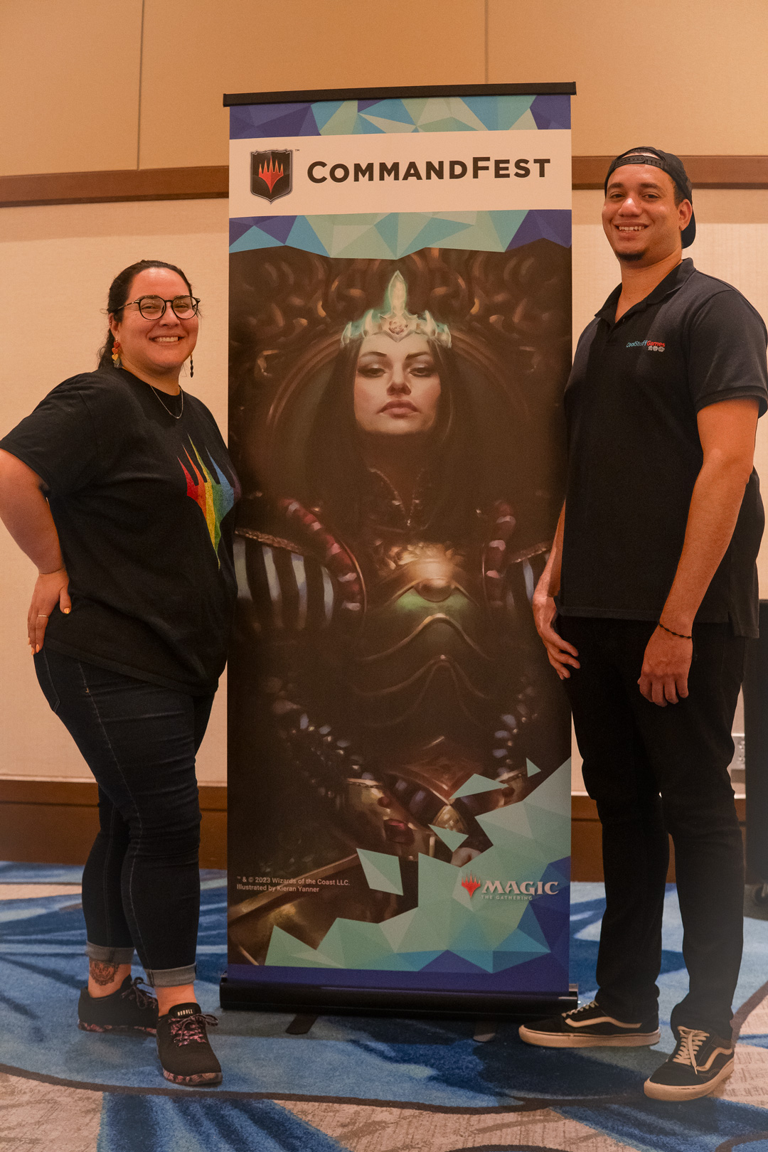 Showrunners Adriana and Jeremy posing in front of CommandFest banner