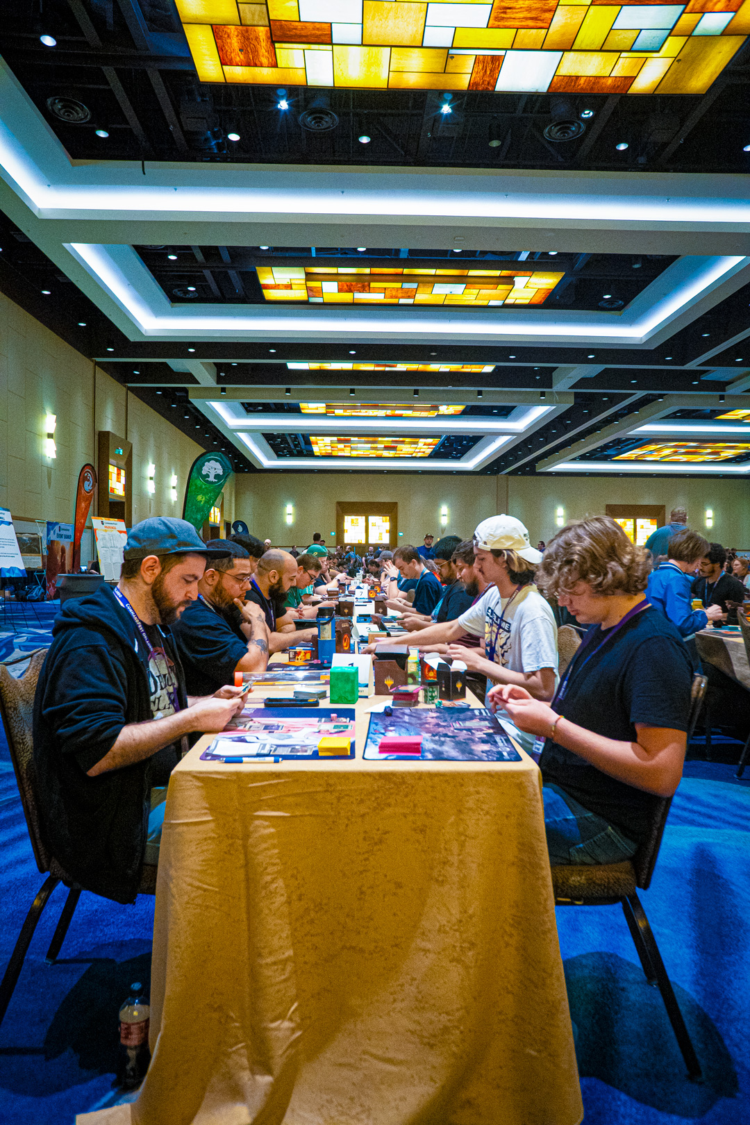 Vertical shot of long table filled with people participating in a prerelease event