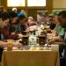 A long table filled with people participating in a prerelease event