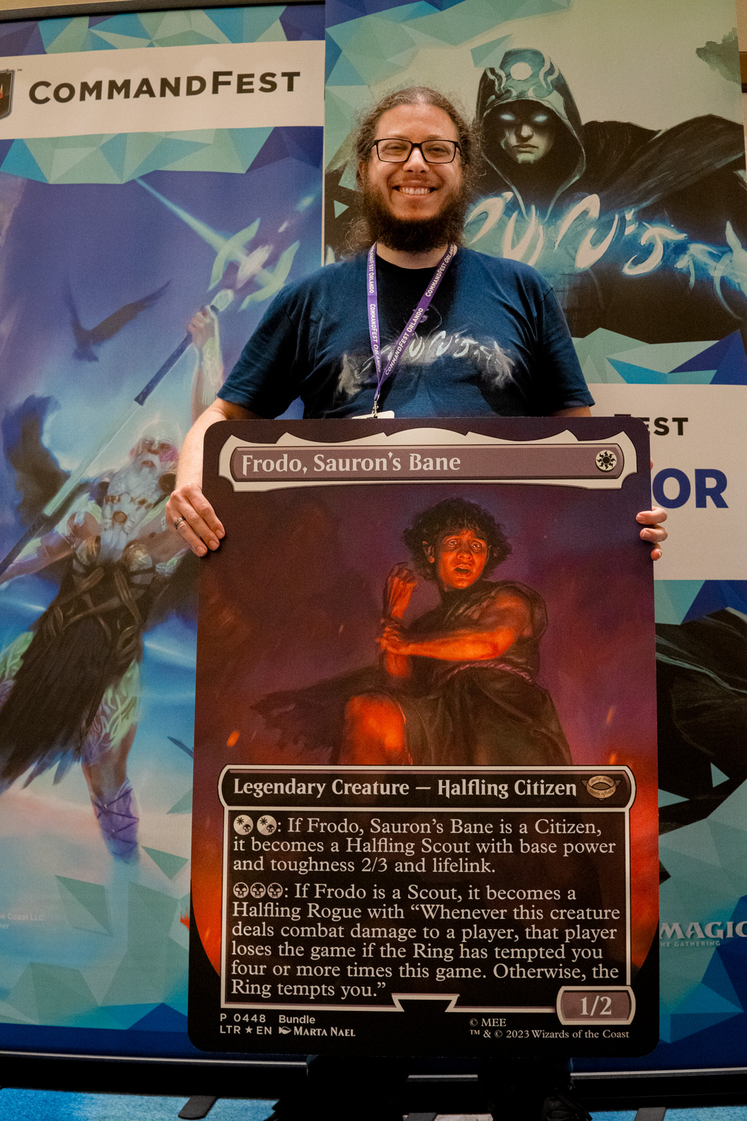 Player holding an oversized card of Frodo, Sauron's Bane