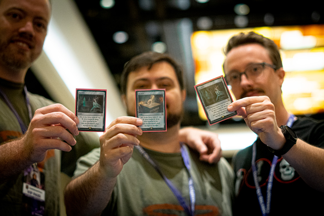 Three male guests posing with cards